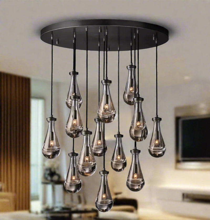 Raine Modern Chandelier with K9 crystal prisms and sleek metal design, perfect for high-ceiling living rooms, foyers, and upscale interiors. Adjustable height, energy-efficient LED compatible.